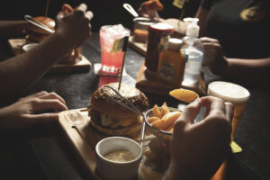 People eating fries and burger at pub